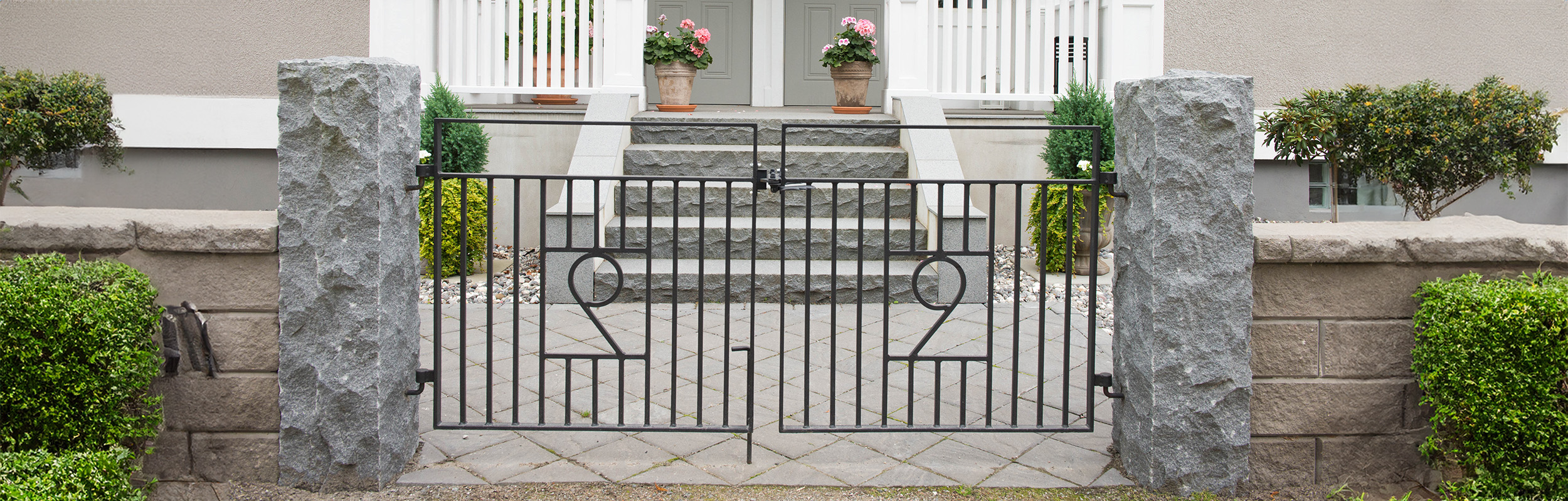 Grind framför granittrappa till husentré och med grindstolpar i granit.