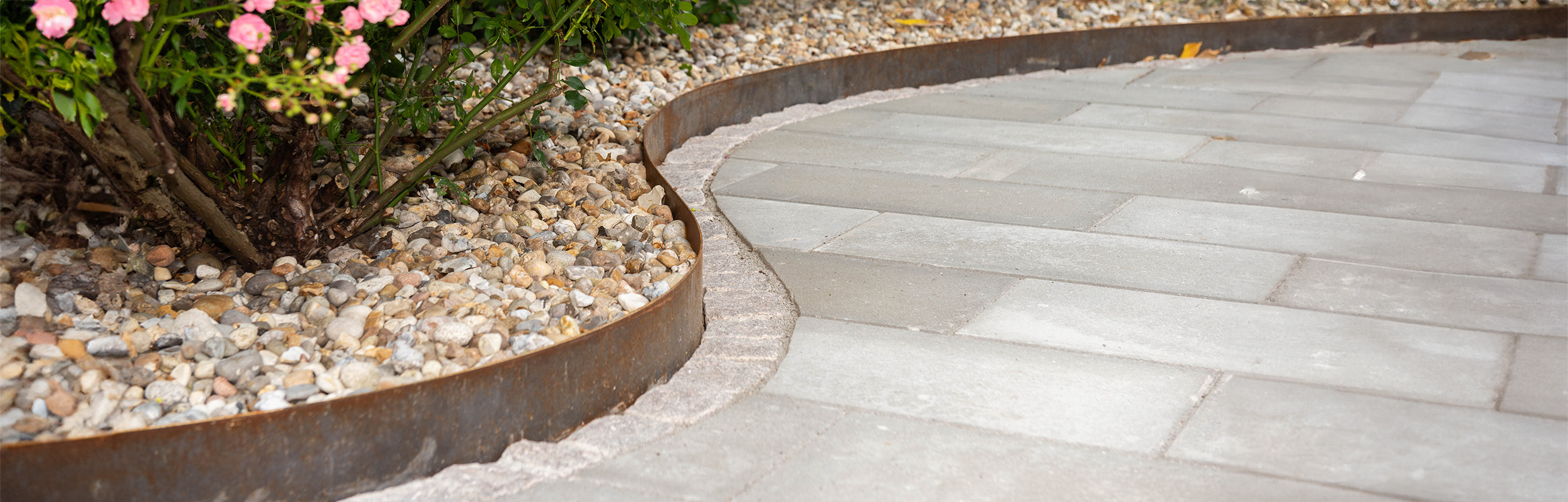 Stenrabatt med sjösten och kantstål i corten med en rad gatsten utanför