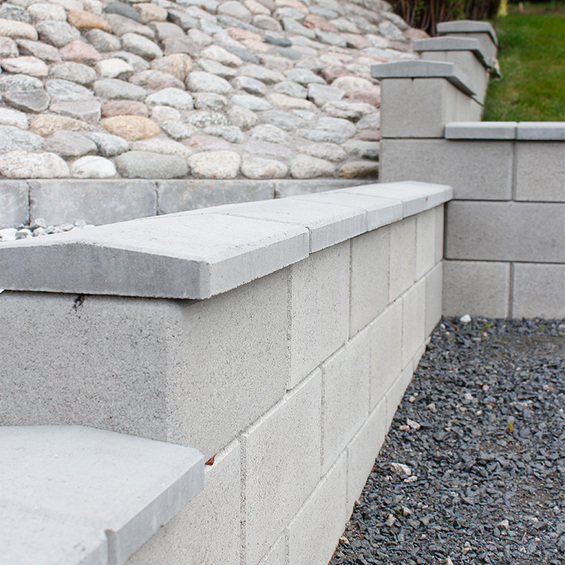 Mur med mursten Gränslös närbild med kullerstensslänt i bakgrunden.