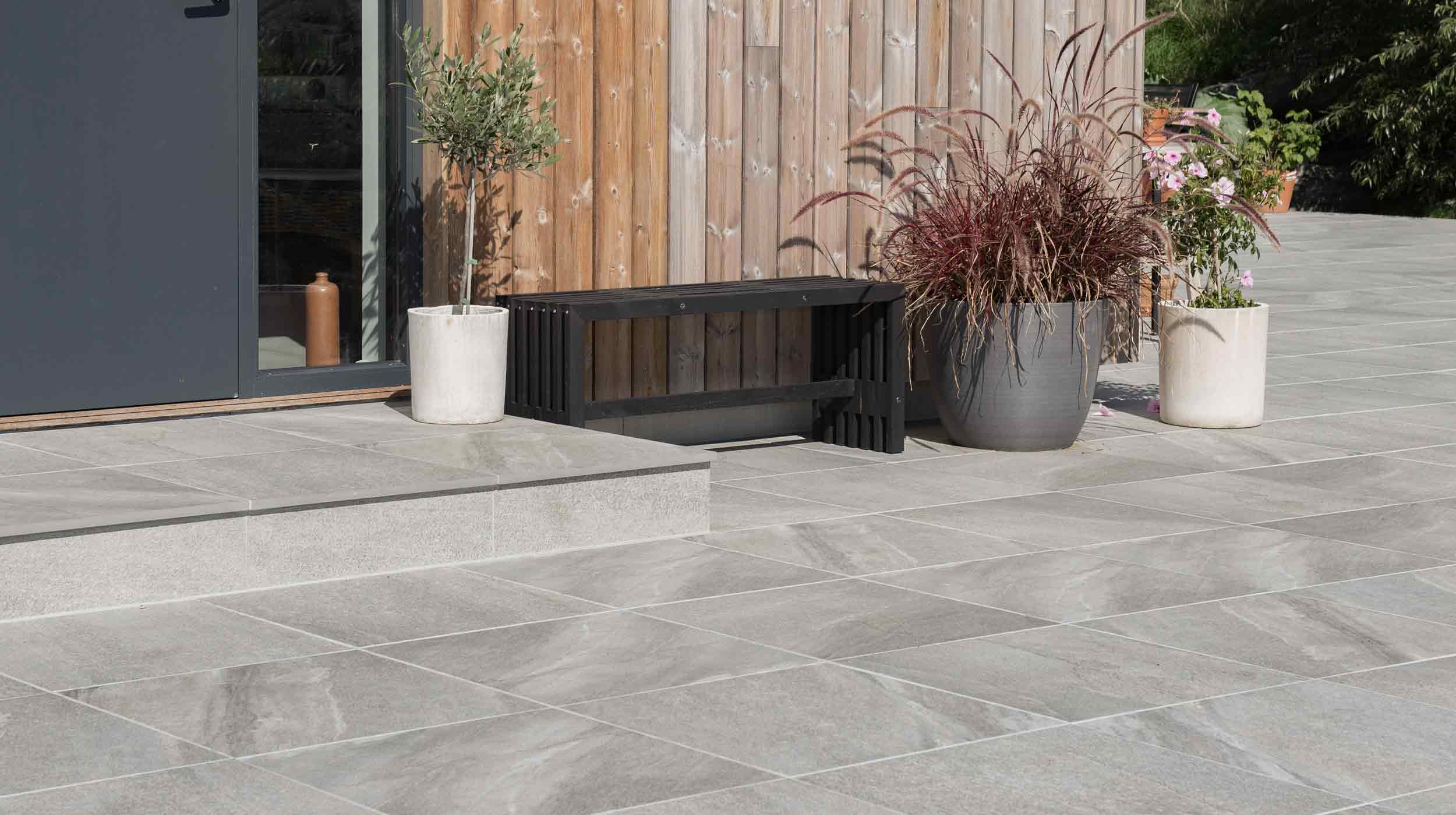 Granitkeramikplattor och en trappa framför en entré.